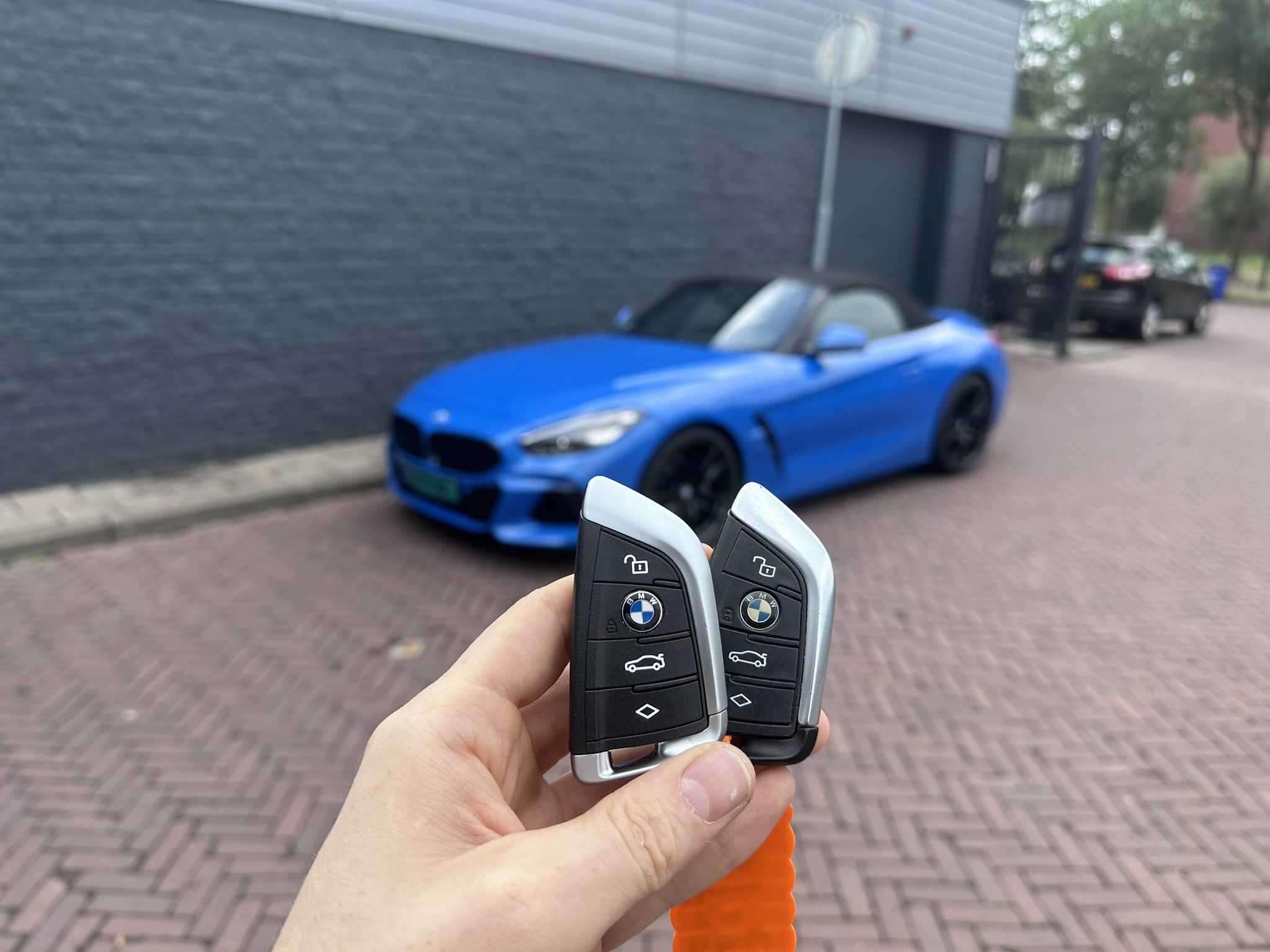 Nieuwe BMW smart key naast het origineel met verkleurd logo, voor een felblauwe BMW Z4 roadster