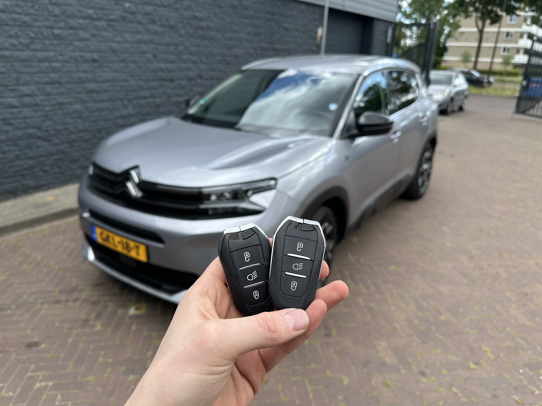 Originele en bijgemaakte keyless sleutel met drie knoppen, voor een grijze Citroën C5 Aircross