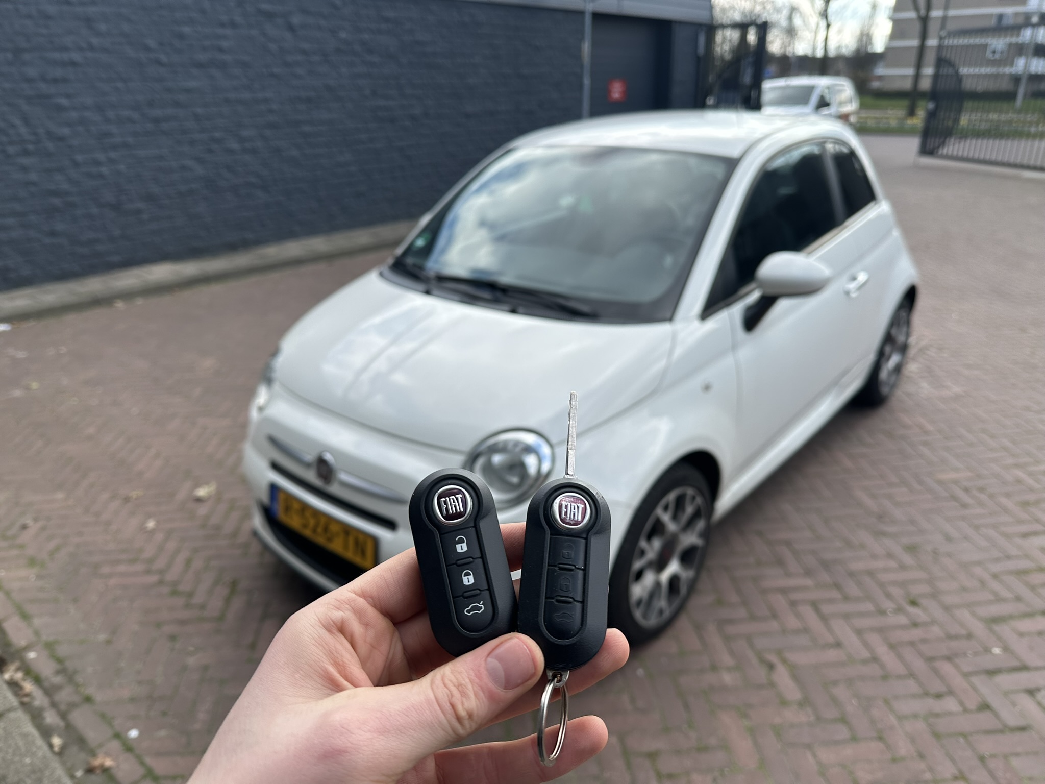 Bijgemaakte Fiat-klapsleutel naast het origineel met versleten knoppen, voor een witte Fiat 500