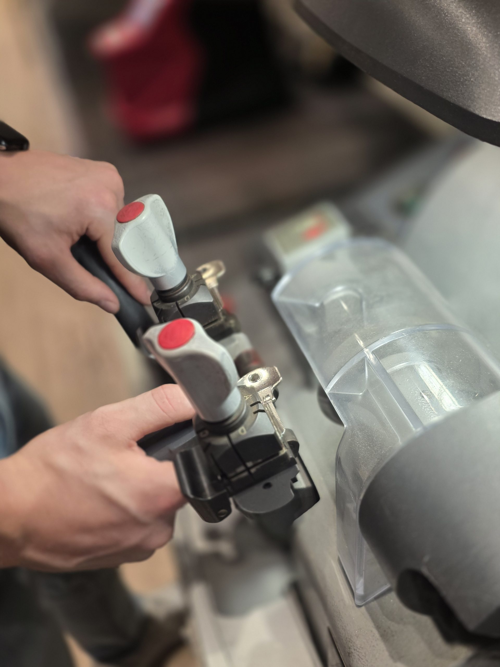 Sleutel wordt bijgemaakt op de sleutelmachine in de werkplaats